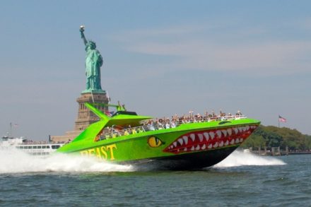 The Beast riding in front of the Statue of Liberty.
